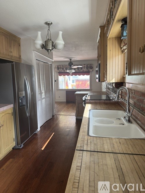 A kitchen with wooden cabinets and a white fridge.