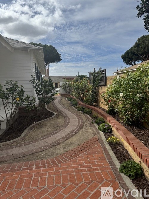 A brick pathway leads through a landscaped garden.