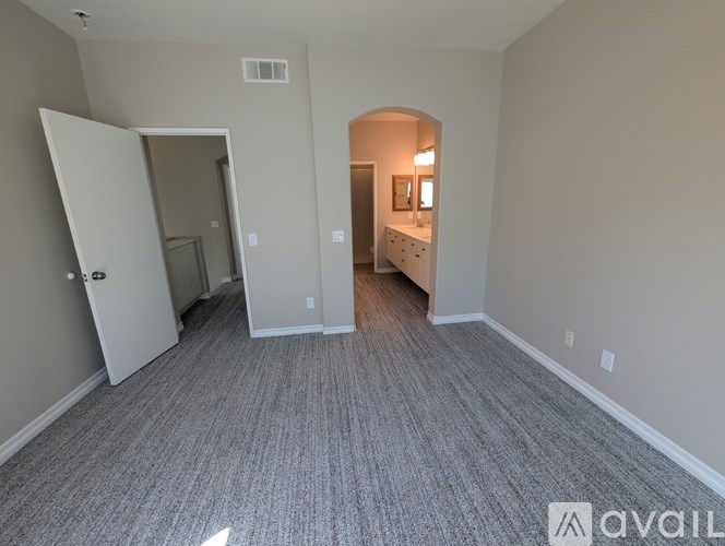A room with carpeted flooring and a white door.