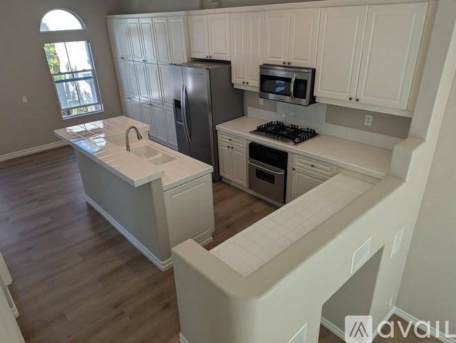 A kitchen with white cabinets and a black stove top oven.