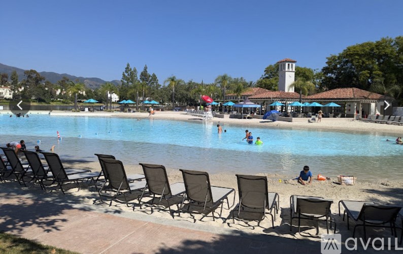 A pool with chairs around it and people in the water.