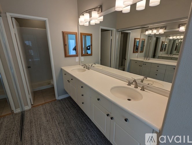A bathroom with a white sink vanity and a mirror above it.