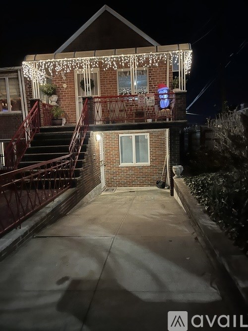 A house with a staircase and a balcony is decorated with Christmas lights.