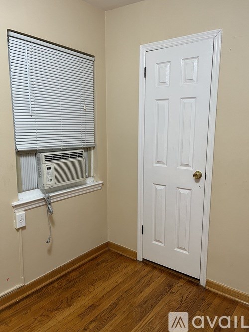 A room with a white door and a window with blinds.