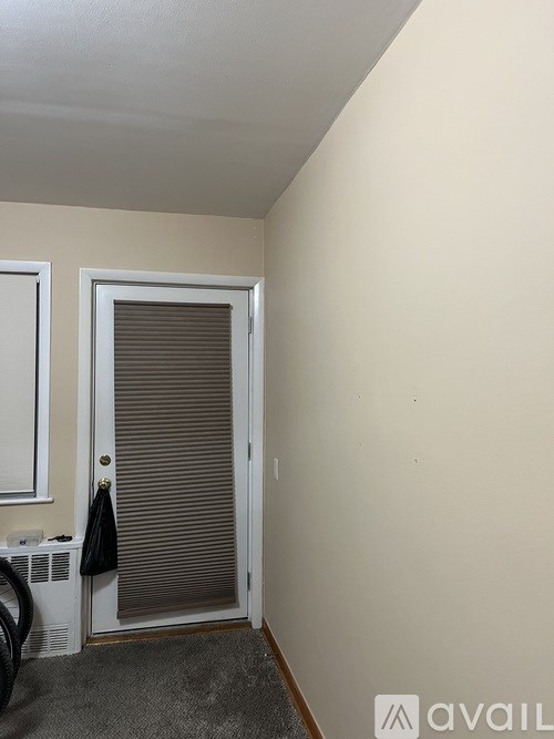 A room with a door, window, and a wall-mounted air conditioner unit.