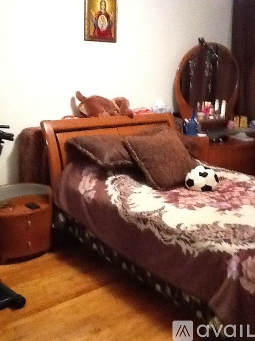 A bed with a brown blanket and a panda toy on it.