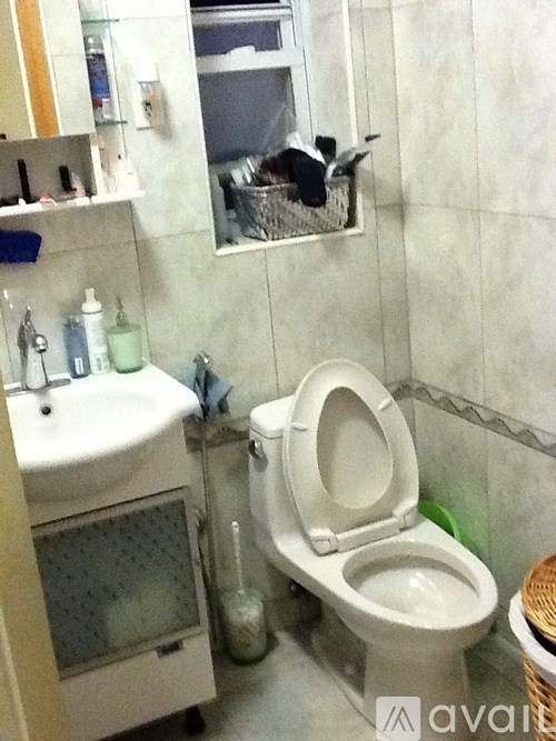A white toilet with a white sink in a small bathroom.