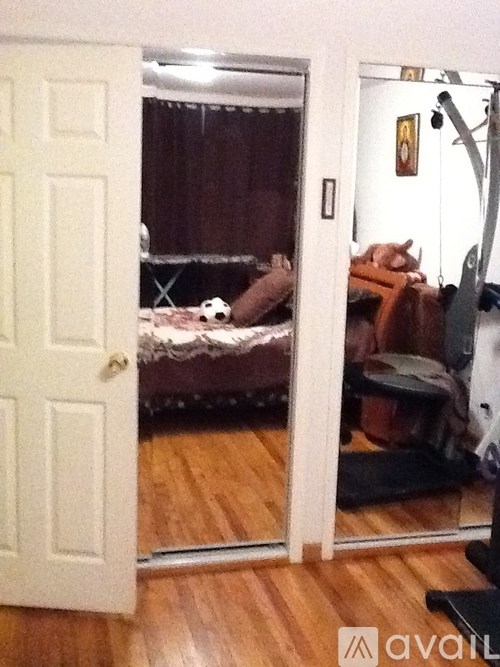 A white door is open to a room with a bed and a couch.