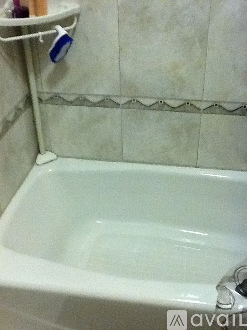 A white bathtub in a bathroom with a towel rack above it.