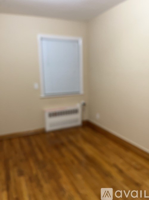 A room with wooden floors and a white window.