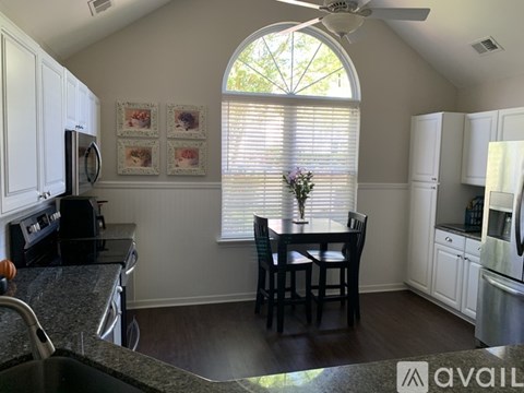 A kitchen with a table and chairs in front of a window.