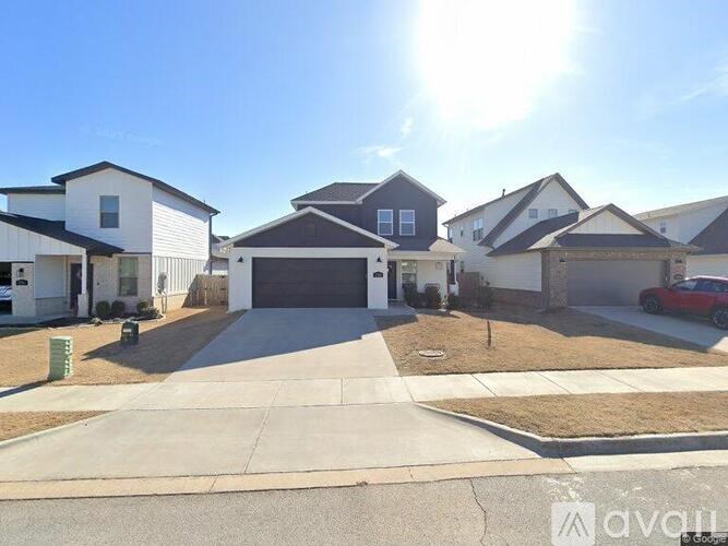A sunny day in a residential area with houses and a car parked in the driveway.