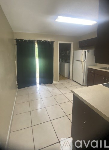 A kitchen with a white fridge and black countertops.