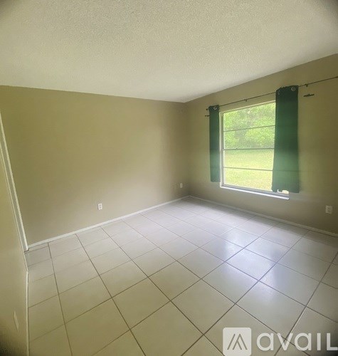 A room with a window and tiled floor.