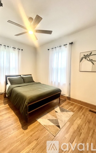A bedroom with a bed, a ceiling fan, and a rug.