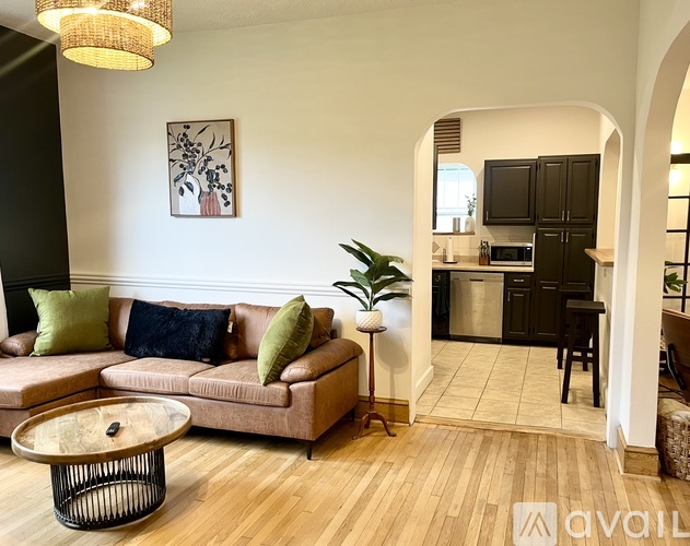 A living room with a couch, a coffee table, and a painting on the wall.