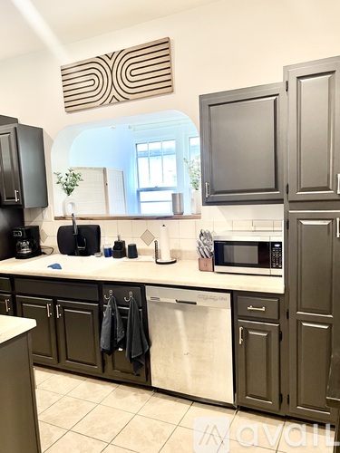 A kitchen with dark brown cabinets and a white counter.