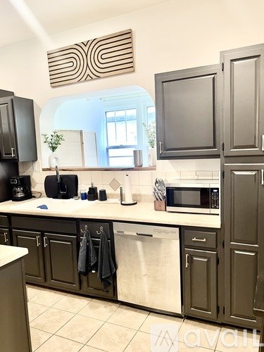 A kitchen with dark brown cabinets and a white counter.