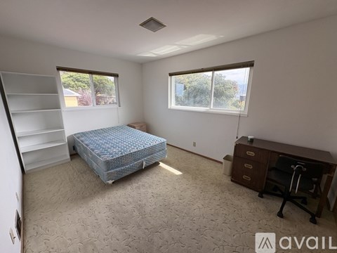 A bedroom with a bed, desk, and chair.