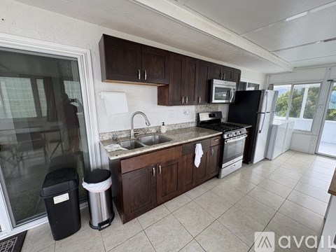 A kitchen with black appliances and brown cabinets.
