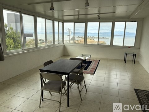 A dining room with a table and chairs overlooking the beach.
