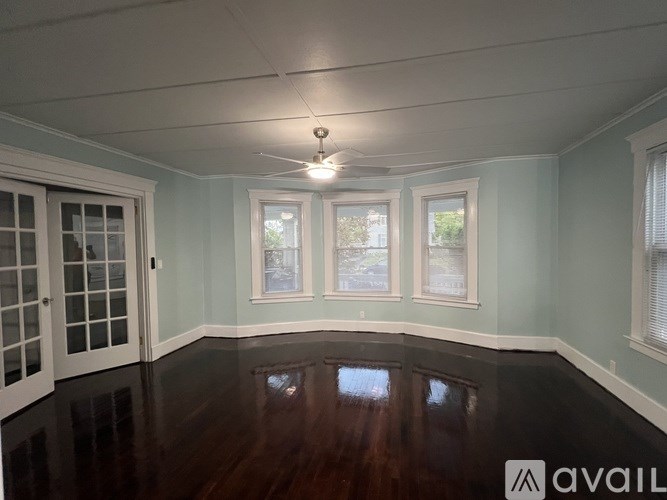 A room with a wooden floor and a ceiling fan.