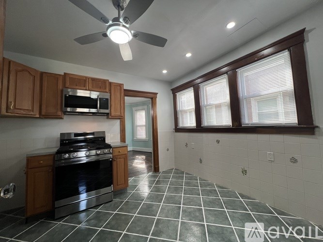 A kitchen with a black stove top oven and a fan.