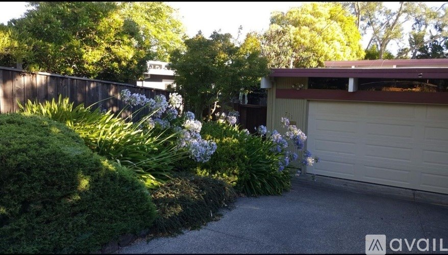 A carport is attached to a house with a garage door.
