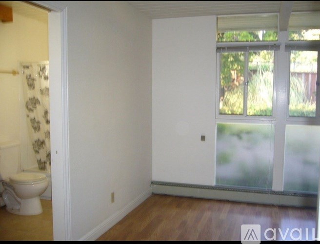 A bathroom with a toilet and a window.