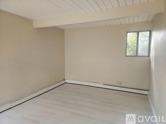 A room with a window and wooden flooring is available for rent.