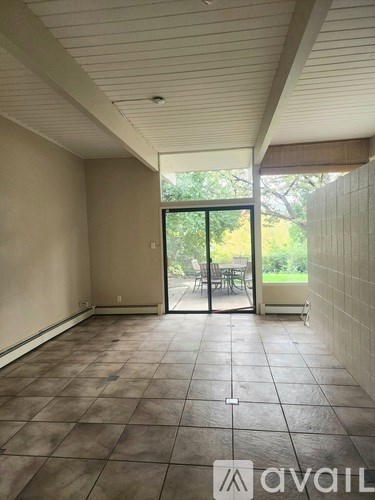 A room with tiled flooring and a sliding glass door leading to a patio.