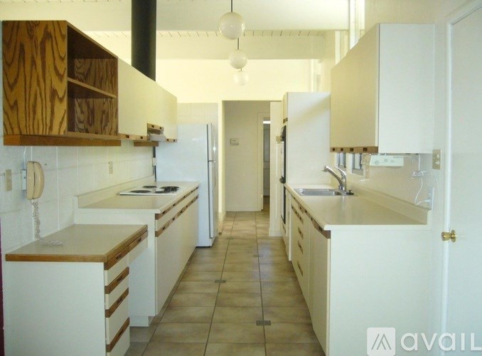 A kitchen with white cabinets and a wooden counter top.