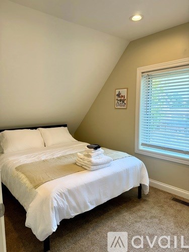 A bedroom with a bed, pillows, and towels neatly arranged.