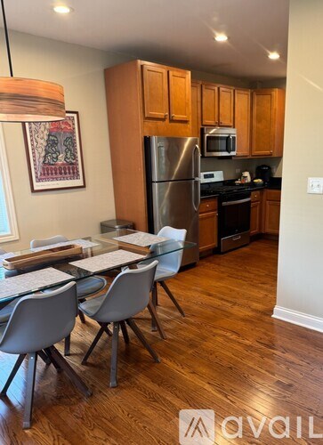 A kitchen with a table and chairs in front of a refrigerator.