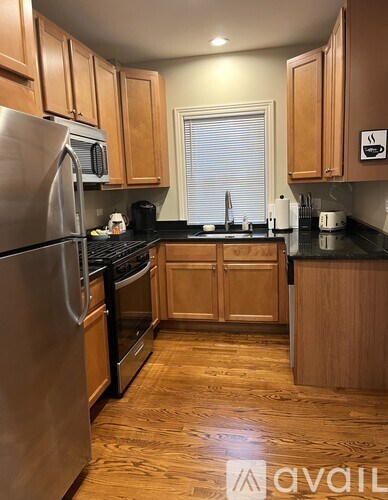A kitchen with wooden cabinets and a stainless steel refrigerator.