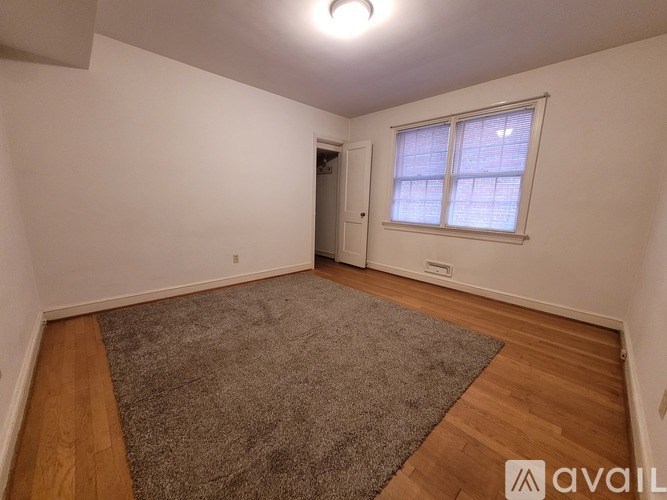 A room with a grey carpet and wooden flooring.