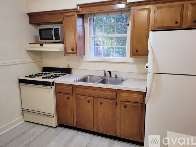 A kitchen with wooden cabinets and a white refrigerator.