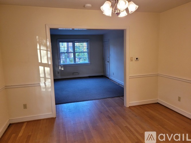 A room with wooden floors and a chandelier.