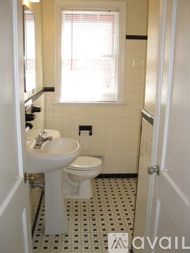 A bathroom with a toilet, sink and a window.