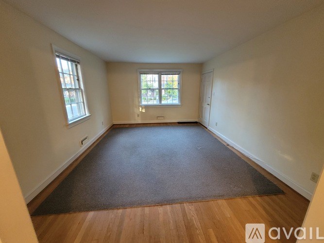 A room with wooden floors and two windows.