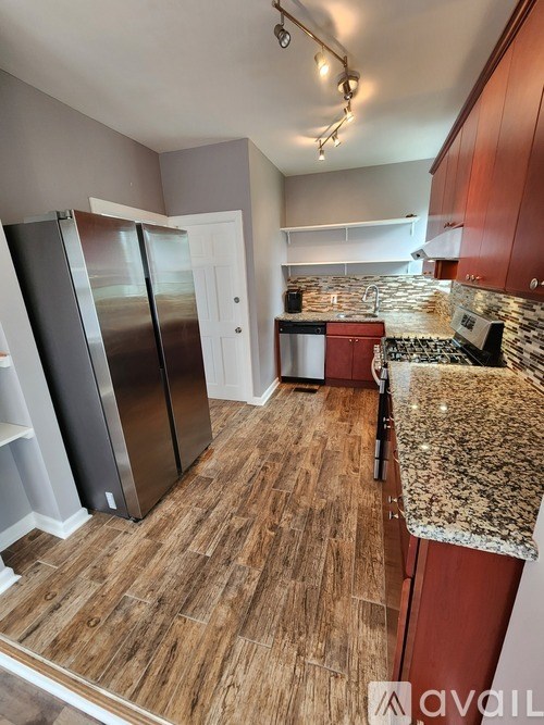 A kitchen with wooden floors and a granite countertop.