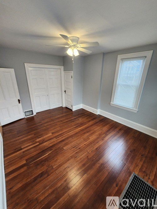 A room with wooden floors and a ceiling fan.