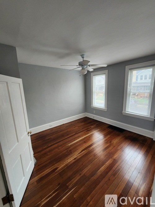 A room with wooden flooring and a ceiling fan.