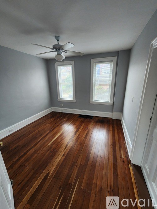 A room with wooden floors and a ceiling fan.