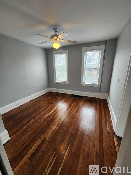 A room with wooden floors and a ceiling fan.