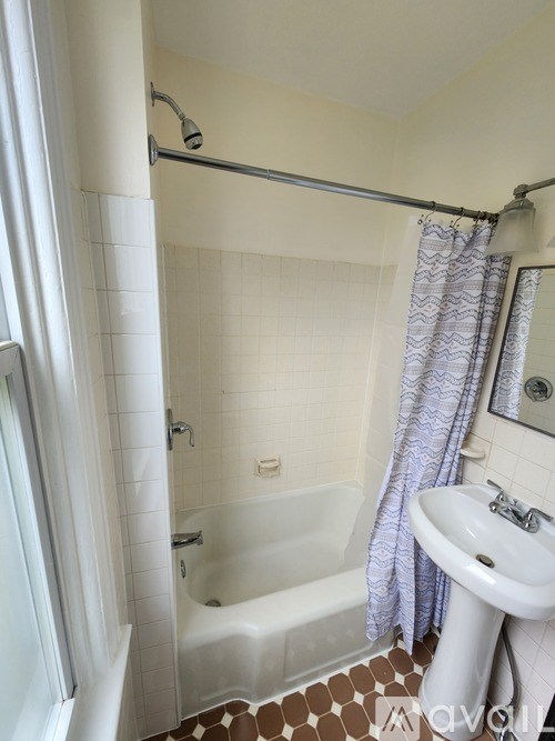 A white sink is under a mirror in a bathroom.