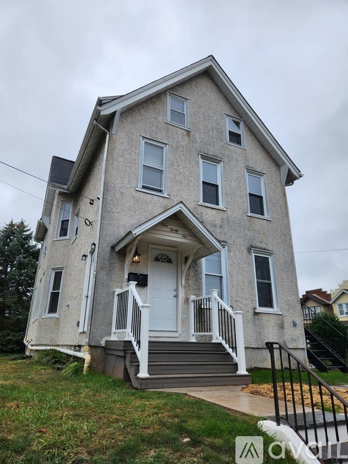 A two-story house with a front porch and a white door.