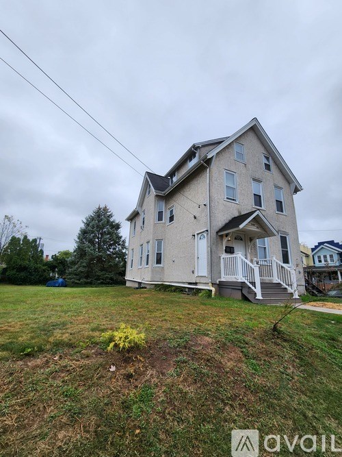 A two-story house with a front porch and a small front yard.