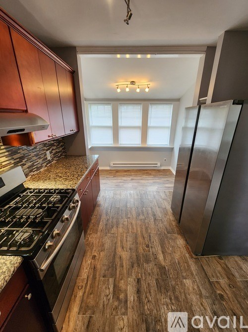 A kitchen with wooden floors and a stove top oven.