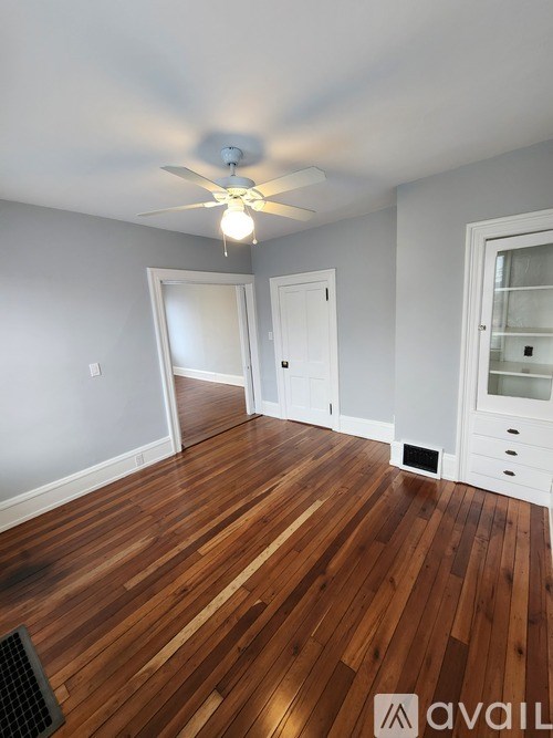 A room with wooden floors and a ceiling fan.